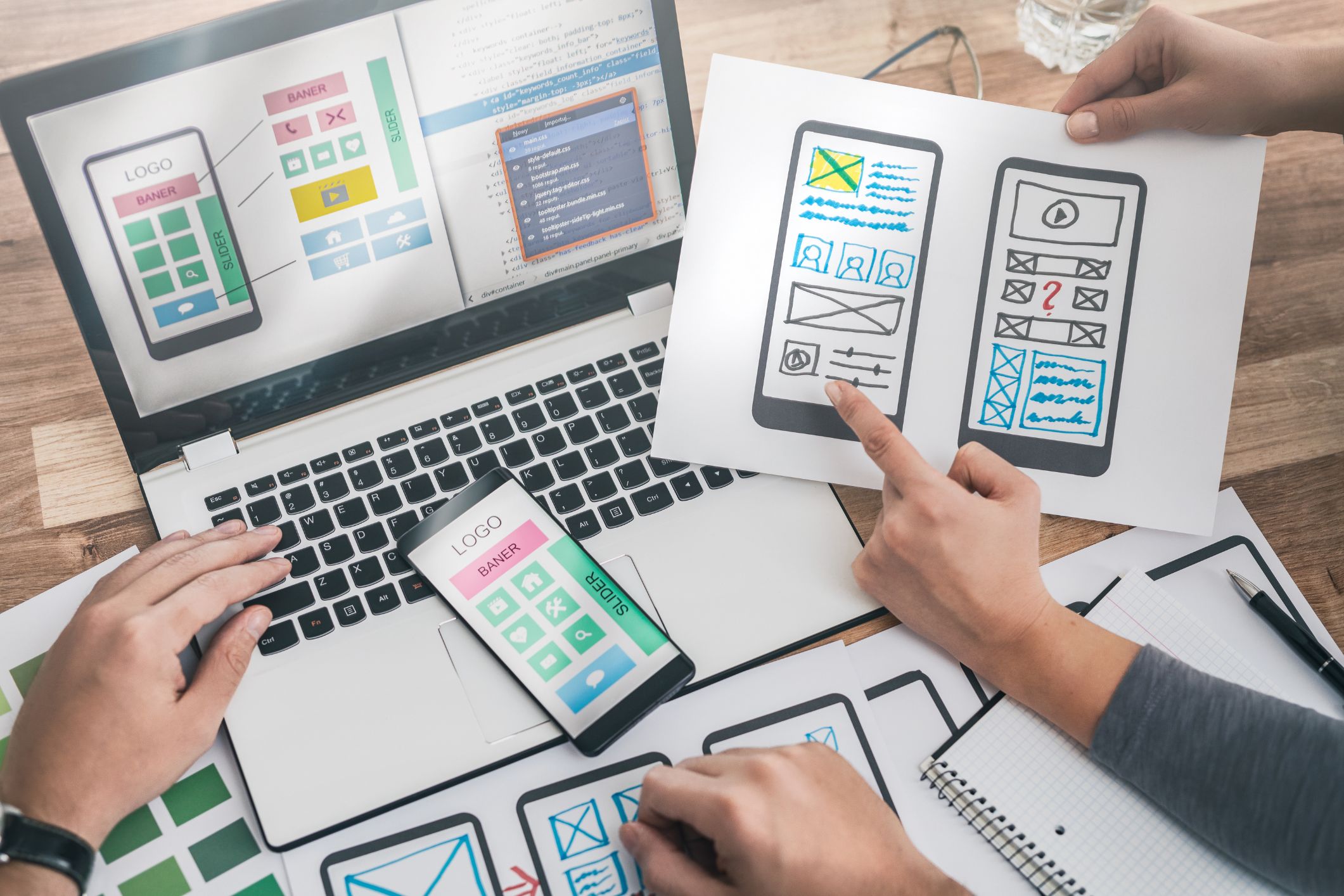 Website wireframes and code on screen